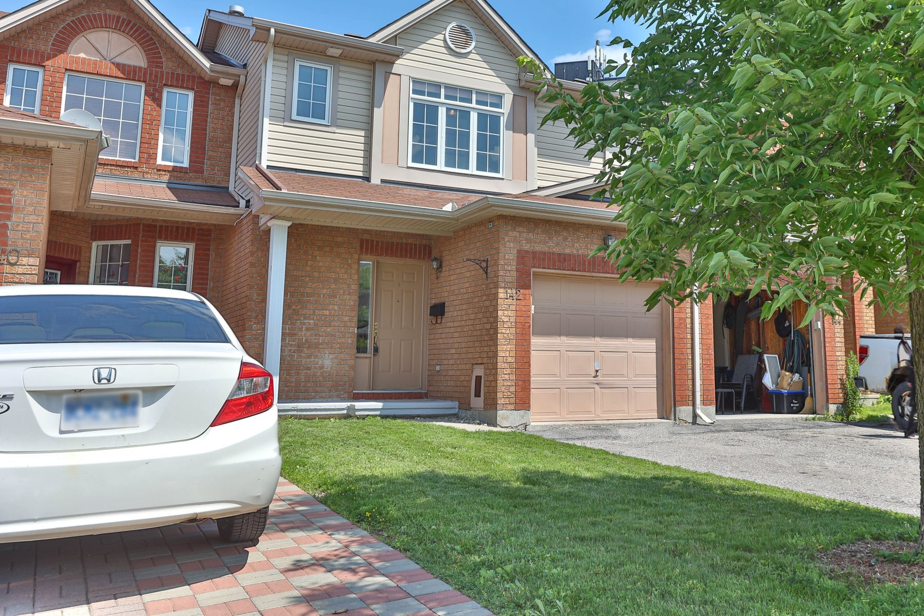 Brick and siding townhouse façade with a bay window, Ottawa