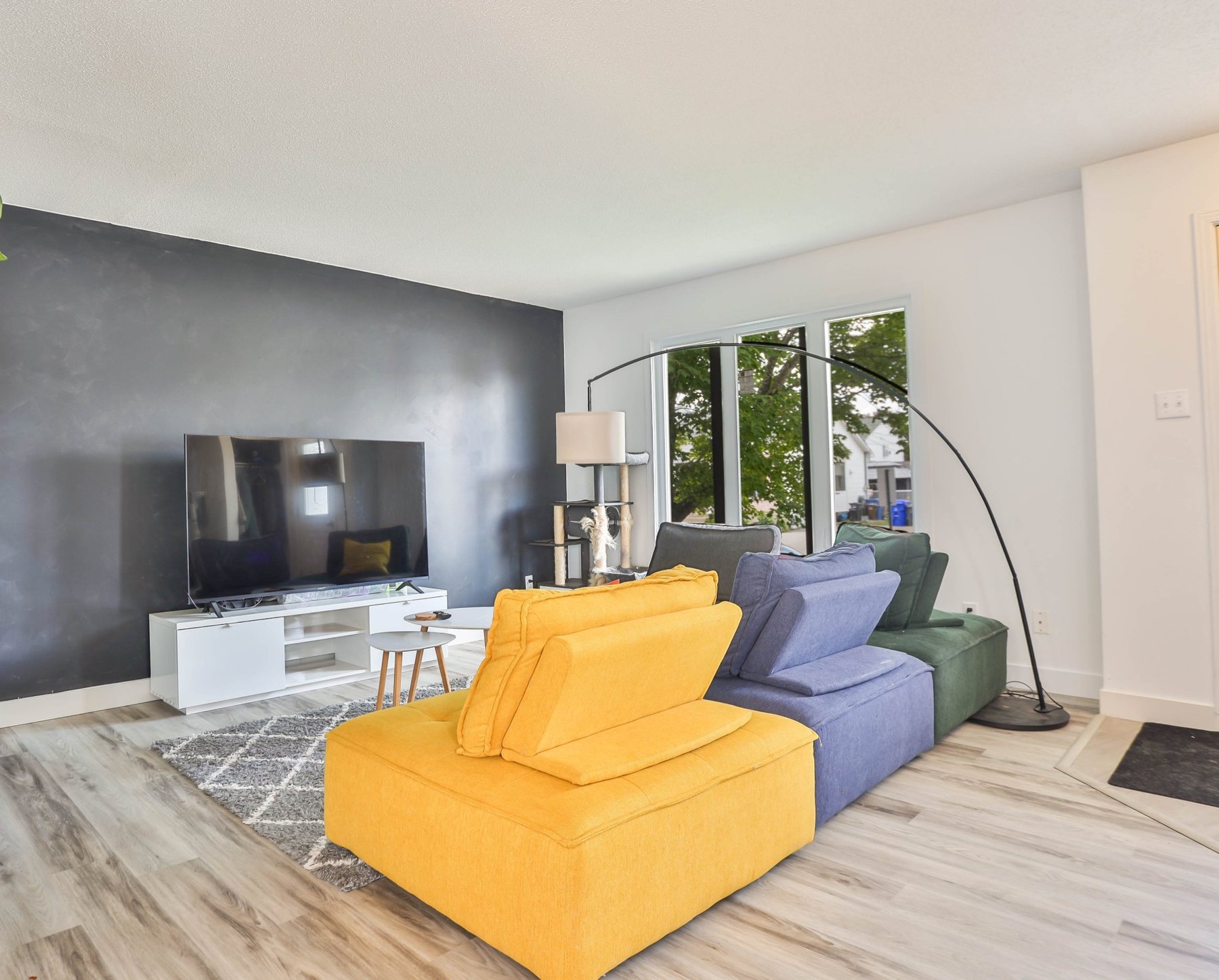 Living room with charcoal accent wall and modular sofa beside a large window